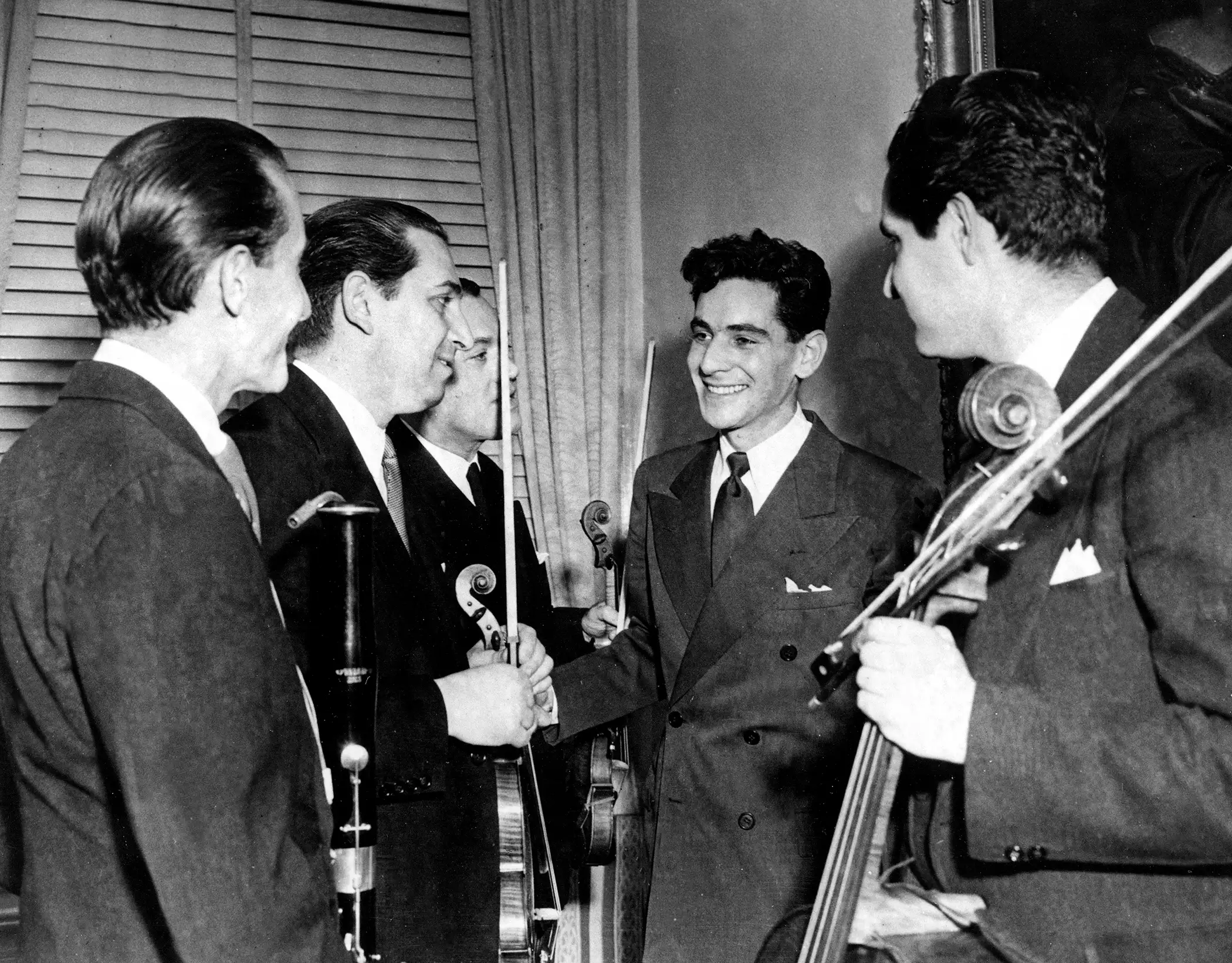 Leonard Bernstein, second from right, Assistant Conductor of the New York Philharmonic-Symphony Orchestra, is congratulated by members of the orchestra after the 25-year-old musician made his debut at Carnegie Hall in New York, Nov. 14, 1943. Bernstein substituted for Bruno Walter, who had become ill, to lead the organization in a 90-minute national radio broadcast.