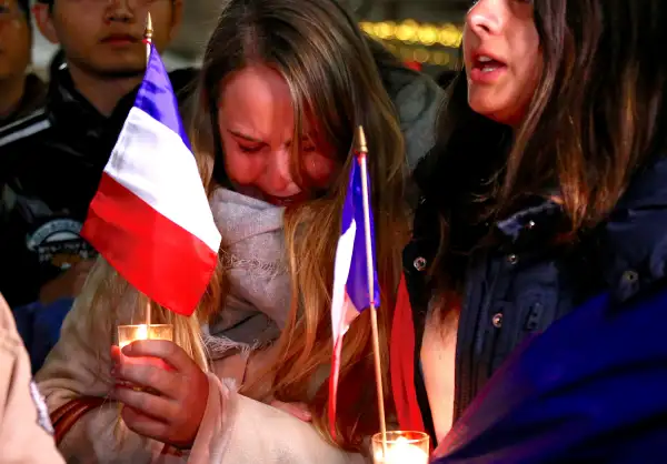 Members of the Australian French community cry as they sing the French national anthem during a vigil in central Sydney, Australia, on July 15, 2016, to remember the victims of the Bastille Day truck attack in Nice.