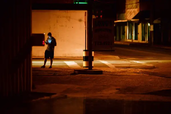 A teenagers plays  Pokemon Go  in downtown Hartselle, Alabama, at night on July 13, 2016.