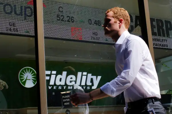 A pedestrian walks past a stock ticker at a Fidelity Investments office in Boston, Massachusetts, July 31, 2013.