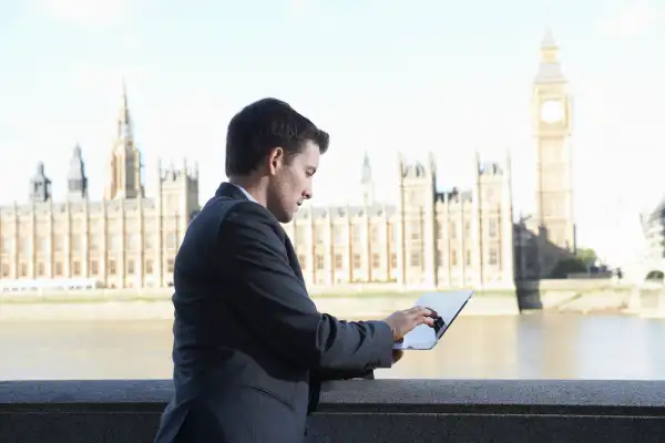 business man using digital tablet near westminster