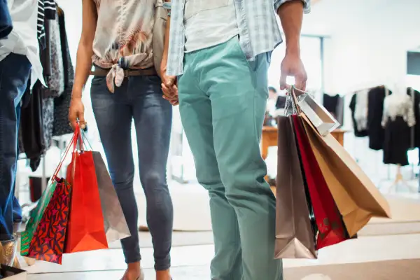 Couple carrying shopping bags in clothing store