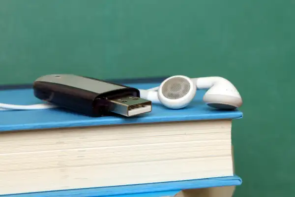 flash drive and headphones on top of books
