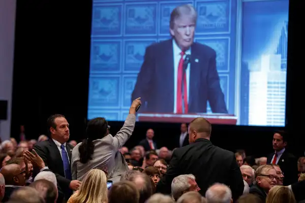 A demonstrator is led away as Republican presidential candidate Donald Trump delivers an economic policy speech to the Detroit Economic Club, Monday, Aug. 8, 2016, in Detroit.