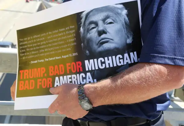 As Republican presidential candidate Donald Trump speaks inside to a business crowd at the Detroit Economic Club at Cobo Center, a protestor holds a sign showing his perspective Aug. 8, 2016 in downtown Detroit, Mich.