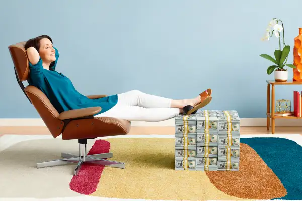 woman in armchair reclining with foot on ottoman of money