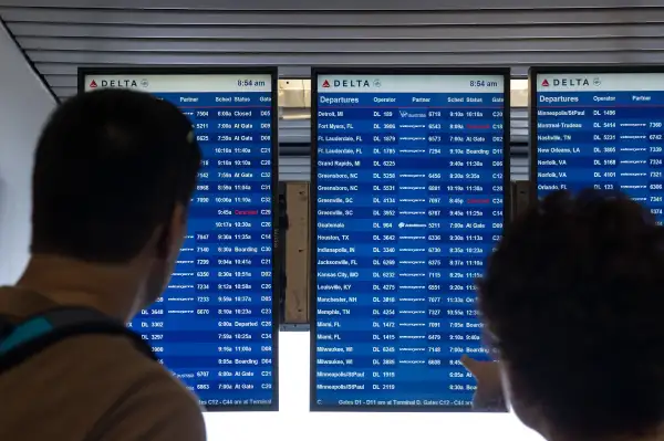NEW YORK, NY - AUGUST 8: Travelers check the Delta departures board at LaGuardia Airport , August 8, 2016 in the Queens borough of New York City. Delta flights around the globe were grounded and delayed on Monday morning due to a system outage.
