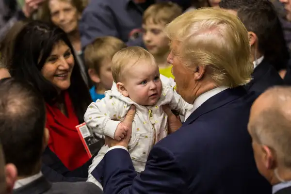 Republican presidential hopeful Donald Trump holds a baby the end of a rally at Great Bay Community College on February 4, 2016 in Portsmouth, New Hampshire.