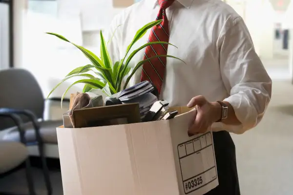 man carrying box of personal items out of office