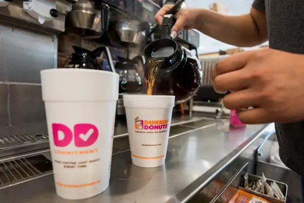 An employee fills a coffee order at a Dunkin' Donuts Inc. location
