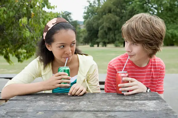 Teenage couple drinking fizzy drinks