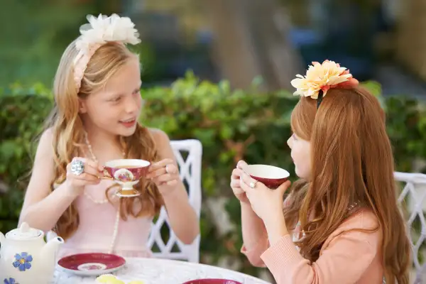 Two young girls having a tea party in the backyard