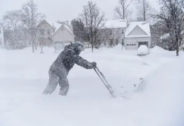 Jocelyn McCoy plows out her neighbors as a major snow storm hits the Washington DC region on January 23, 2016 in Crofton, MD.