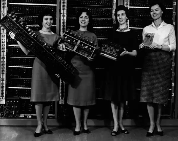 Women holding the first four computer circuit boards. From left to right: Mrs. Patsy Simmers with the ENIAC (Electronic Numerical Integrator And Computer) board; Mrs. Gail Taylor, with the EDVAC (Electronic Discrete Variable Automatic Computer) board; Mrs.