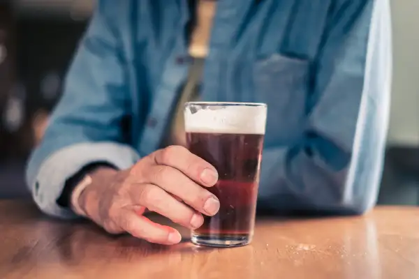 Older man holding glass for beer