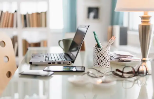 Laptop, cell phone and office supplies on desk