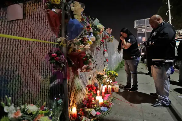Sol Rodriguez, center, and Aaron Torres visit a shrine for the victims of a warehouse fire near the site Sunday, Dec. 4, 2016, in Oakland, Calif. The death toll was expected to rise, as crews using buckets and shovels slowly made their way through the building, finding victims where they least expected them, Alameda County Sheriff's Sgt. Ray Kelly said.