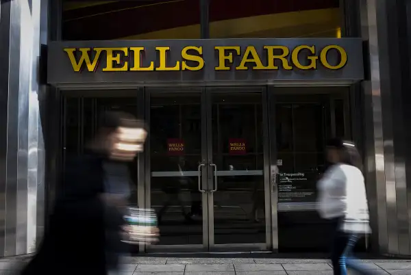 Pedestrians walk past Wells Fargo branch.