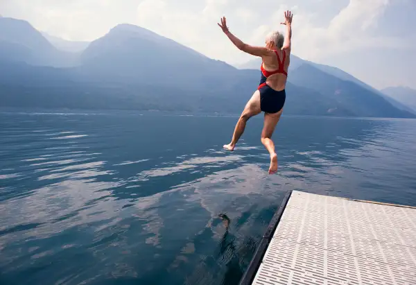 eldery woman jumping lake mountains