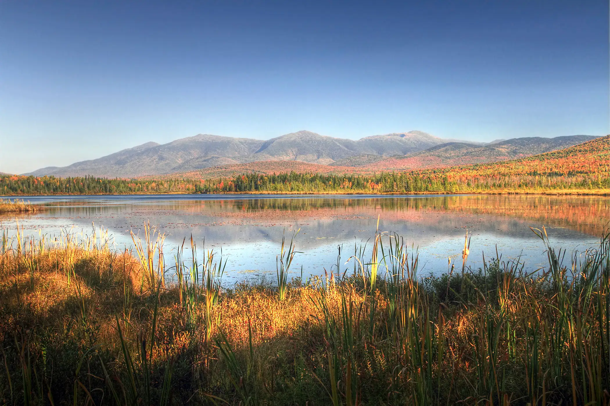 A view across Cherry Pond or Pondicherry with White Mountains Presidential range in background.