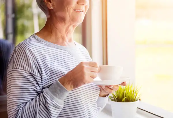 Senior woman holding fresh coffee