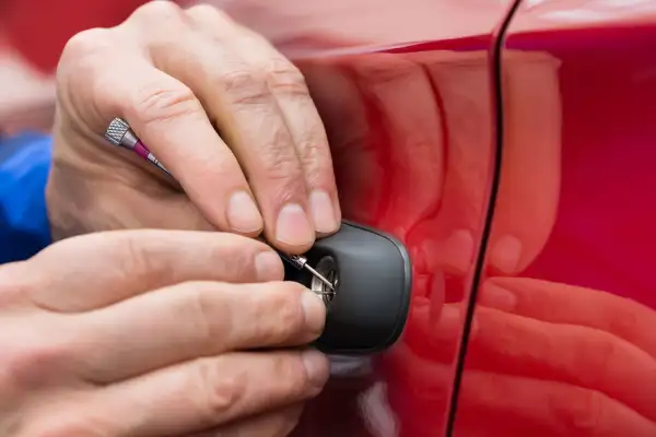 Close-up Of Person Hand Holding Lockpicker To Open Car Door