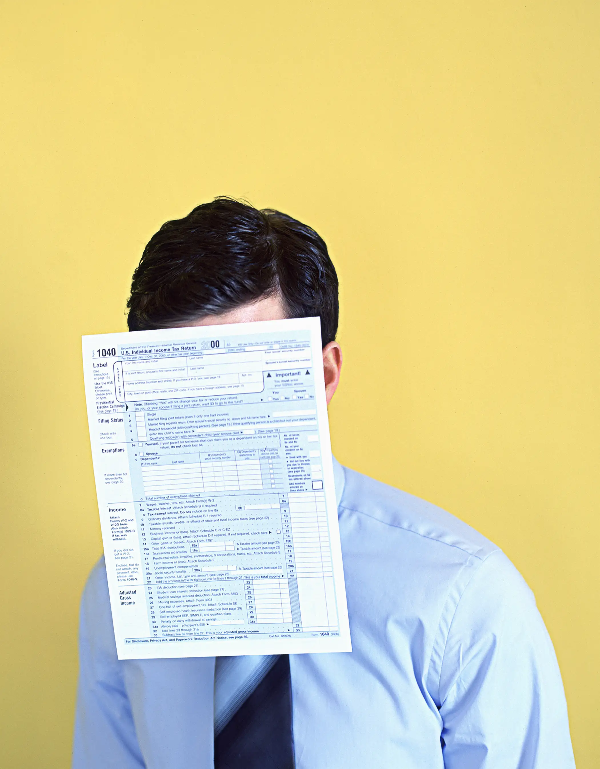Man With 1040 tax form covering face