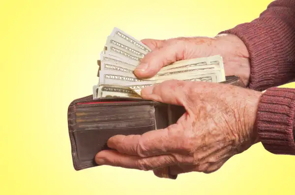 senior pulling money out of wallet