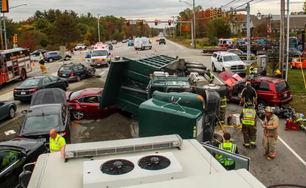 Emergency personnel investigate the scene of a 10-vehicle accident, Thursday, Oct. 13, 2016 in York, Maine. The accident happened when a dump truck filled with dirt tipped onto its side, demolishing a number of cars and sending multiple people to the hospital.