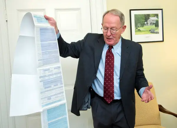 Sen. Lamar Alexander, R-Tenn., shows the Free Application for Federal Student Aid (FAFSA) form, during an interview with the Associated Press on Capitol Hill in Washington, Friday, Nov. 14, 2014.