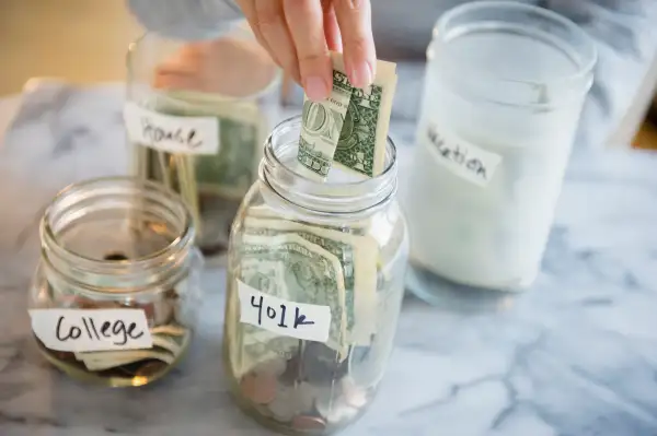 Mixed race woman saving money in jars