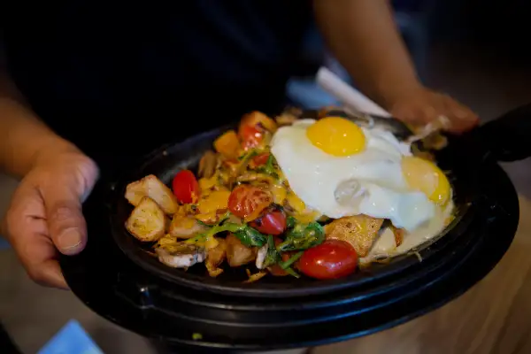 A waitress displays an Ultimate Skillet menu item for a photograph while delivering it to a customer at the Denny's Corp. restaurant in New York, on Sept. 6, 2014.