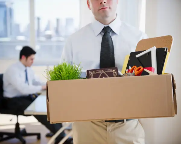 Fired Caucasian businessman carrying personal belongings