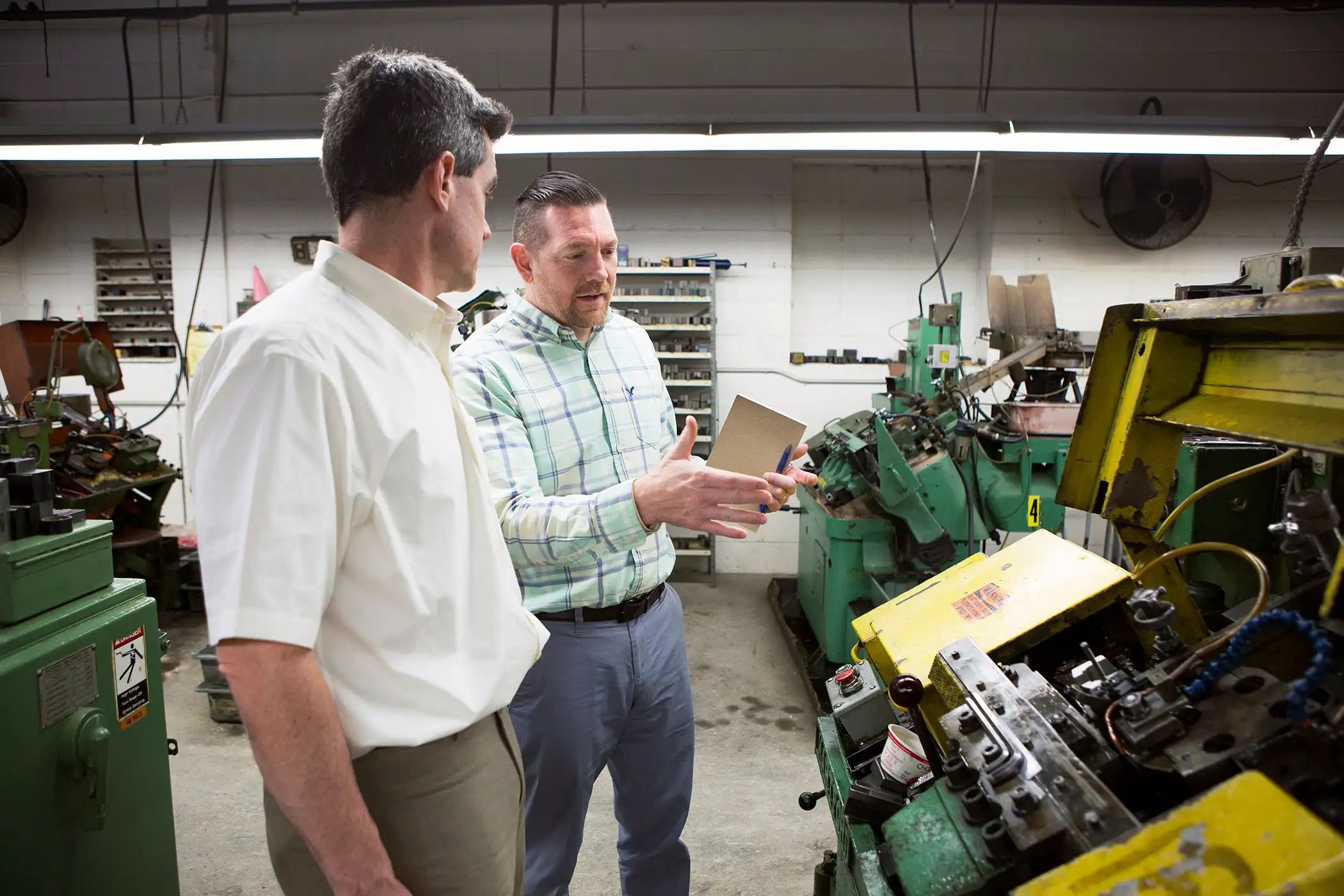 Nathan Bonds (right) talks with Christian Cowan (left), the Center Director for Polarisâ Manufacturing Extension Partnership, at Rhode Islandâbased manufacturer Pilgrim Screw, about ways to improve their efficiencies and projects to improve their current processes and business needs. They make screws used only by the Aviation Industry.