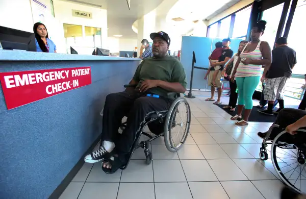 Nikita Hendrix, center (in wheelchair), waits to be treated for a pressure sore on his foot, during a visit to the emergency room at Long Beach Memorial Hospital on August 13, 2014. In one of the first signs of the effects of Obamacare, most hospitals in Los Angeles County had an increase in visits to their emergency departments in the first part of 2014.