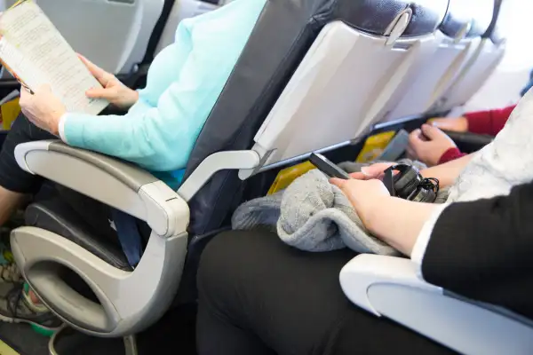 Passengers seated on an airplane are cramped in their seats