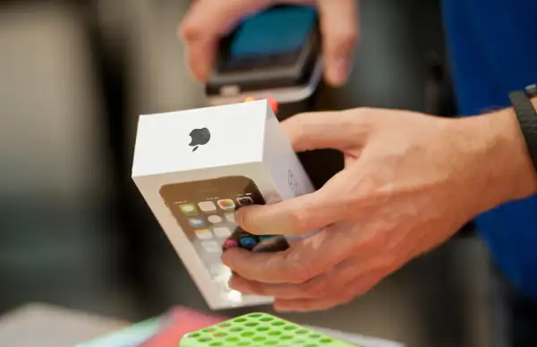 A sale person scans an Apple i-Phone 5s as sales start for the i-phone 5c and 5s in the Apple Store, on September 20, 2013 in Berlin, Germany.