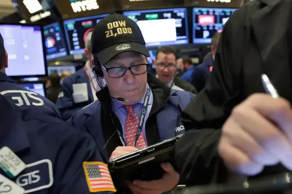 In this Wednesday, March 1, 2017, file photo, trader Richard Cohen wears a  Dow 21,000  cap as he works on the floor of the New York Stock Exchange. Excitement that President Donald Trump will drive business-friendly policies is only one of the reasons behind the stock market’s recent surge.