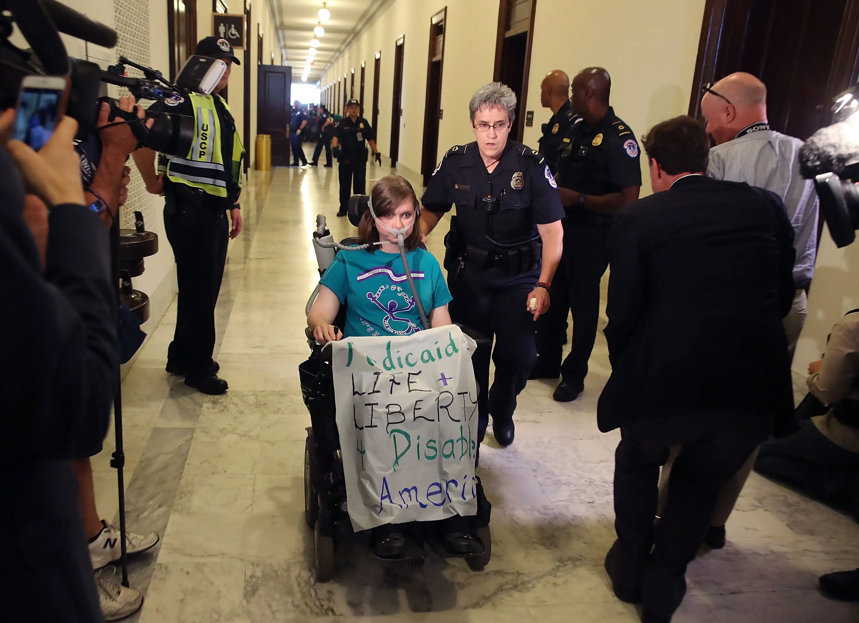 U.S. Capitol Police remove Laura Halvorson, a protester, from in front of the office of Senate Majority Leader Mitch McConnell (R-KY) inside the Russell Senate Office Building on Capitol Hill, on June 22, 2017 in Washington, DC.