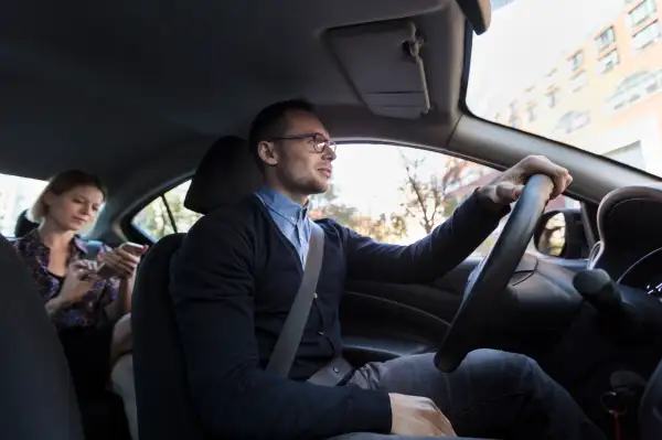 Man driving with woman sitting in car