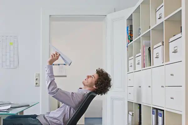 Businessman holding paper airplane