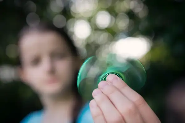 Girl (12-13) using fidget spinner