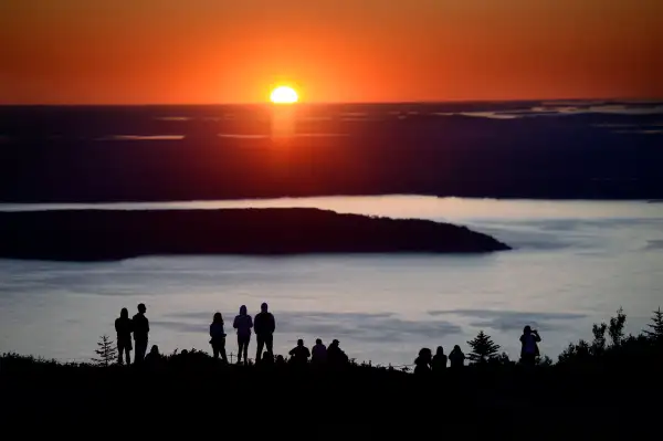 Hundreds of visitors flock to the top of Cadillac Mountain in Acadia National Park to watch the sunrise