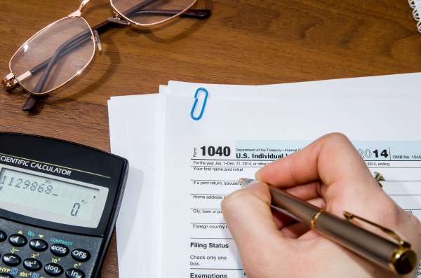 Woman hand filling income tax forms 1040