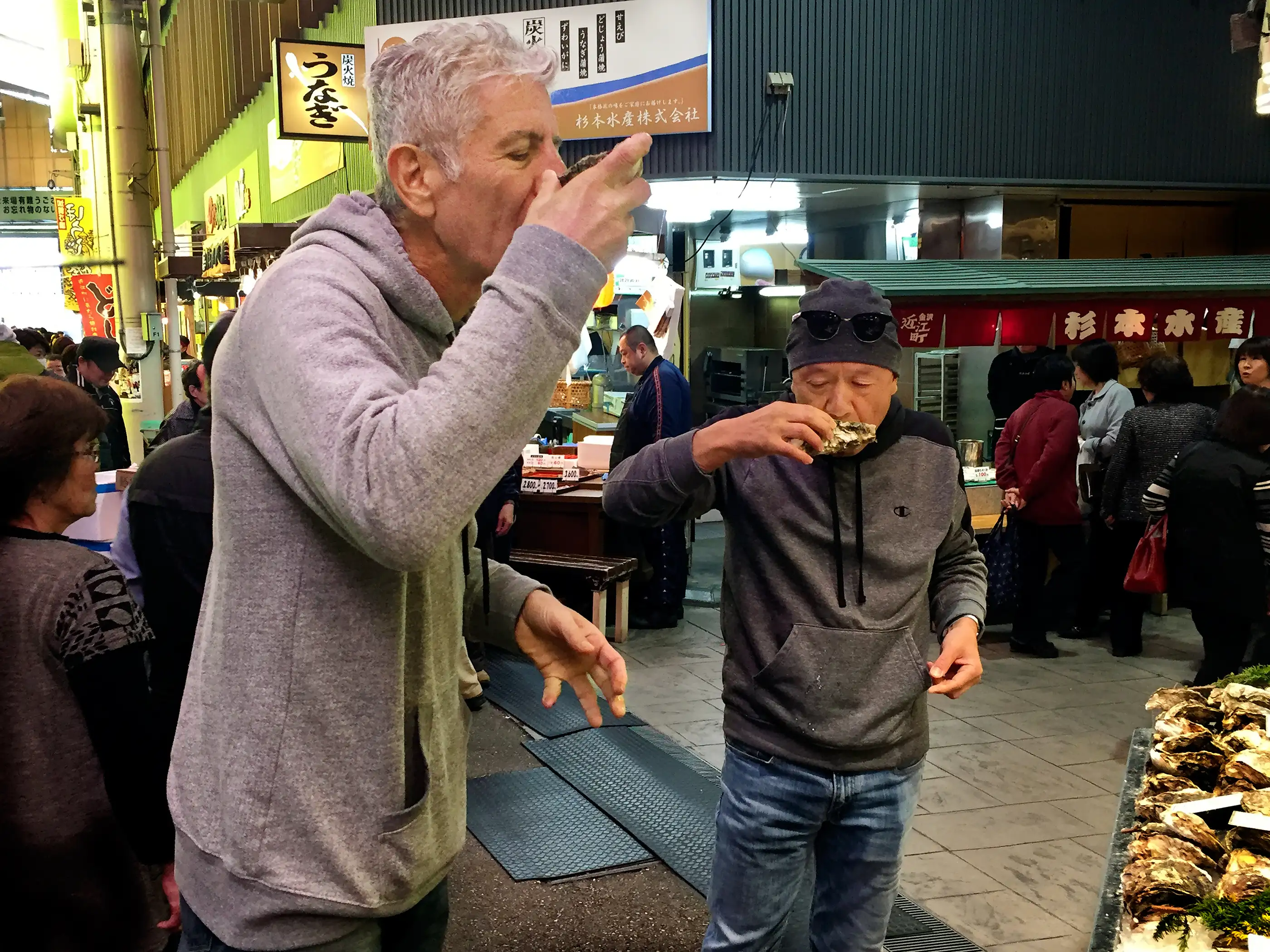 Anthony Bourdain and chef Masa Takayama sample oysters in the streets of Kanazawa, Japan.