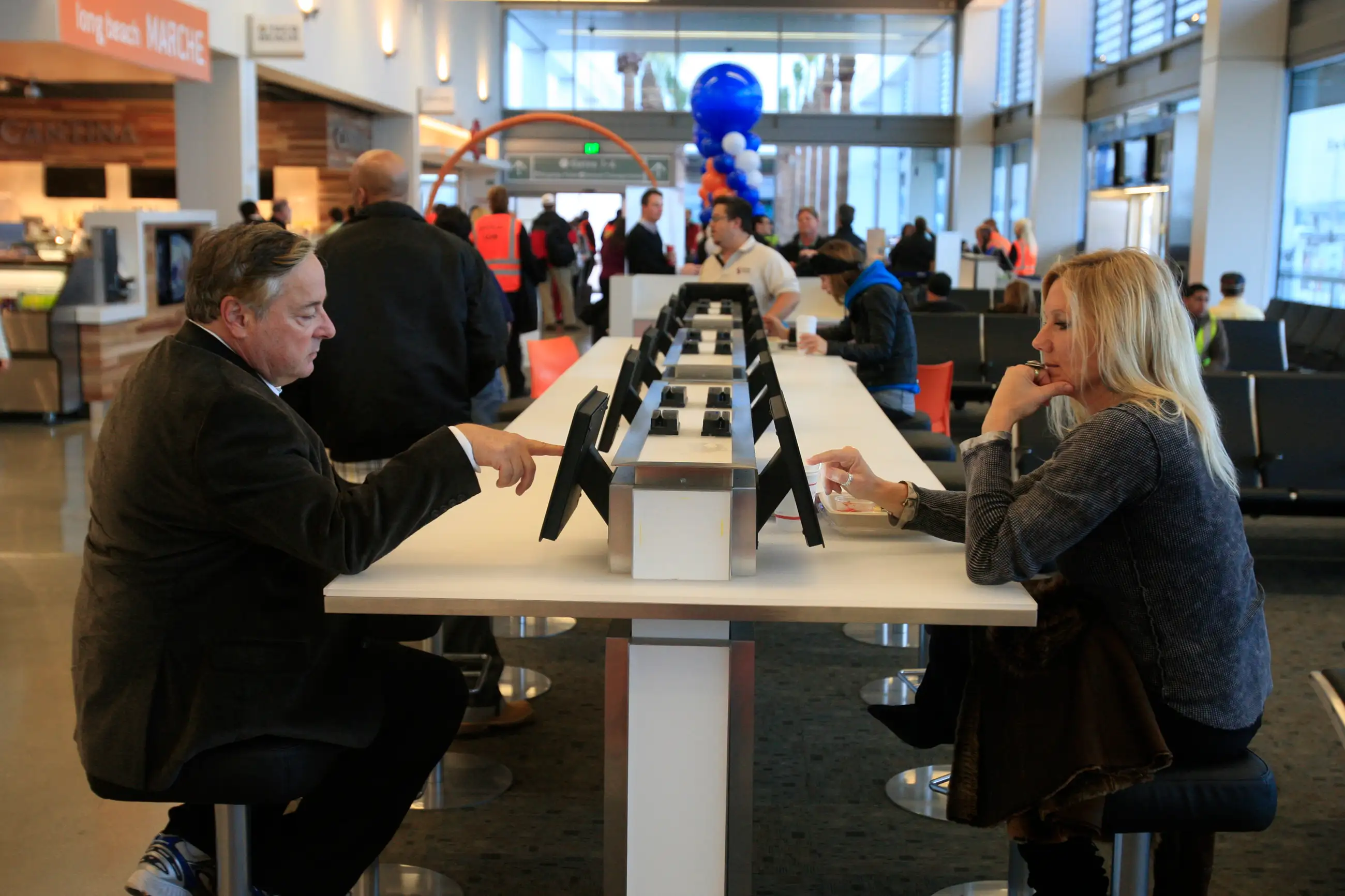 Travelers Steve Gould, left, of Tustin, and Diane Armitage, of Laguna Beach, check out new iPads wh