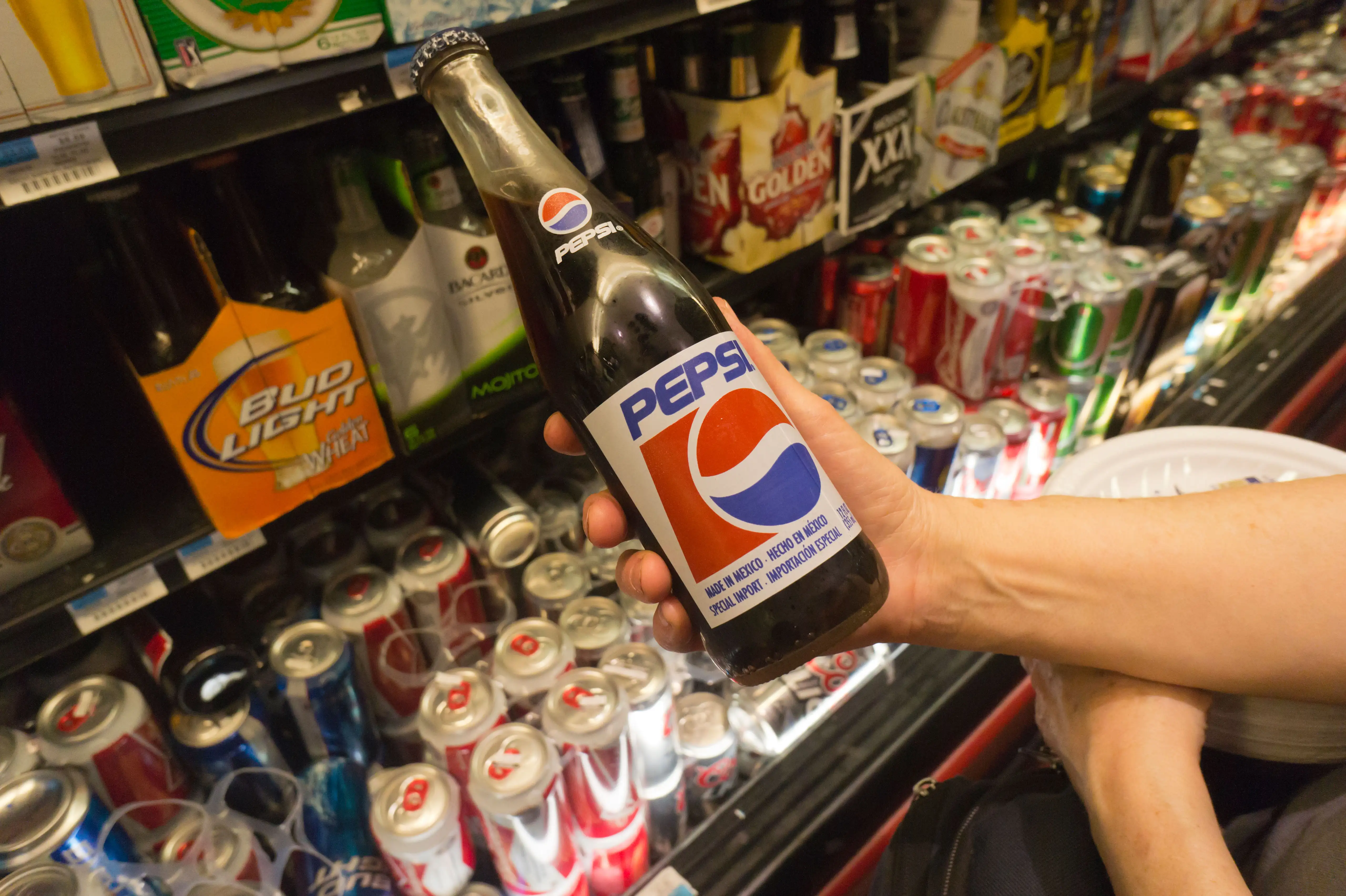 A customer contemplates the purchase of a glass bottle of Pepsi, made in Mexico, in a supermarket in New York.