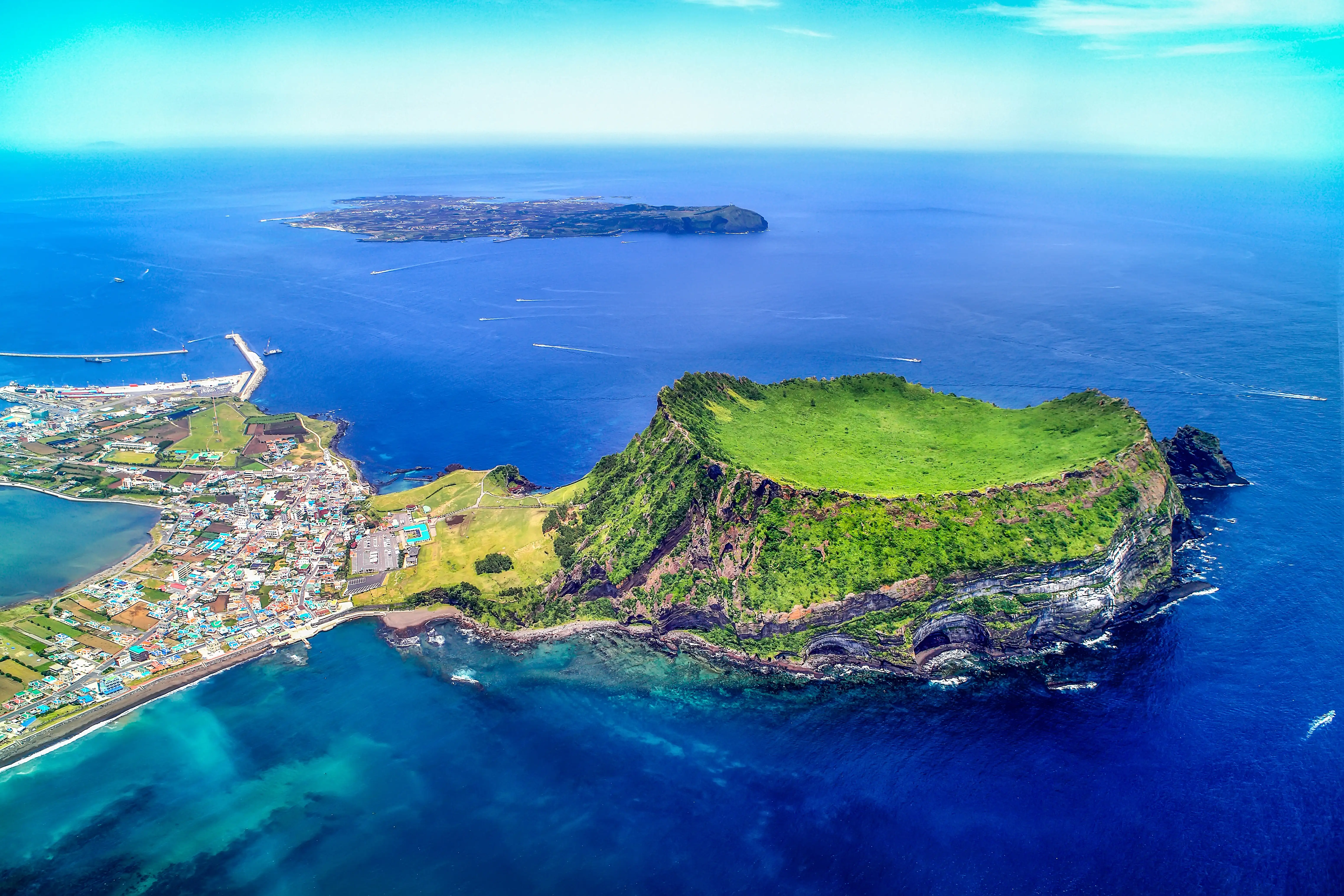 Aerial view of Seongsanilchulbong Cliff (Korea Natural Monument 420, UNESCO World Heritage Site) and Udo Island (Famous travel destination) in Jeju Island