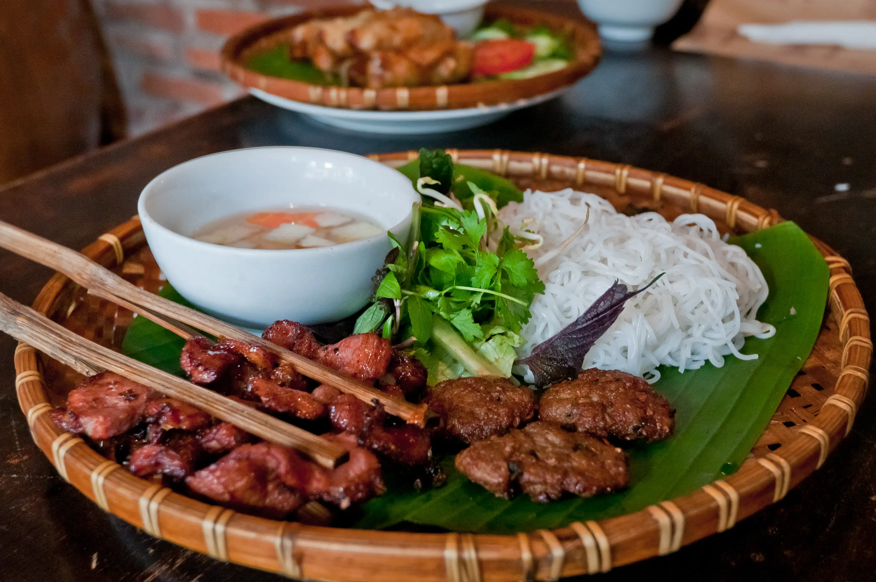 Bun Cha, or Vietnamese cold white rice noodles served with grilled pork and a variety of herbs at a local restaurant at Hanoi, Vietnam.