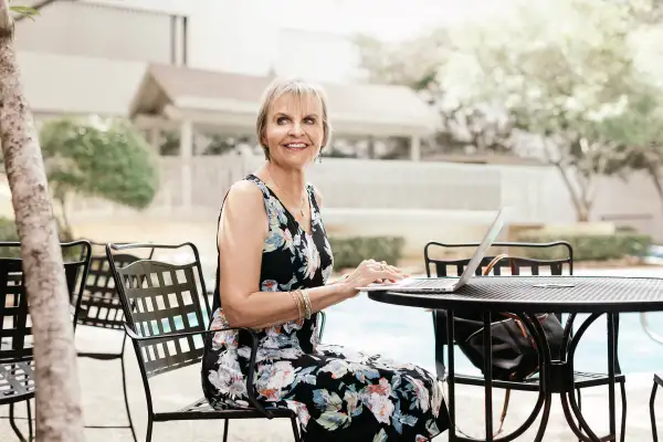 Carol Marak works poolside at her home in Dallas, Texas.